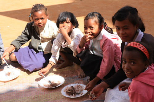 Groupe d`enfants d`Imito partageant le riz de midi